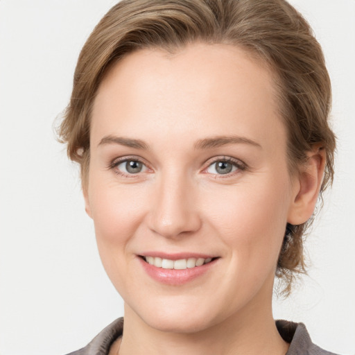 Joyful white young-adult female with medium  brown hair and grey eyes