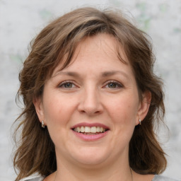 Joyful white adult female with medium  brown hair and grey eyes