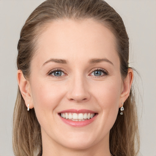 Joyful white young-adult female with long  brown hair and grey eyes