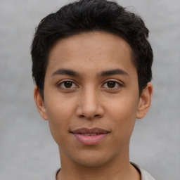 Joyful latino young-adult male with short  brown hair and brown eyes