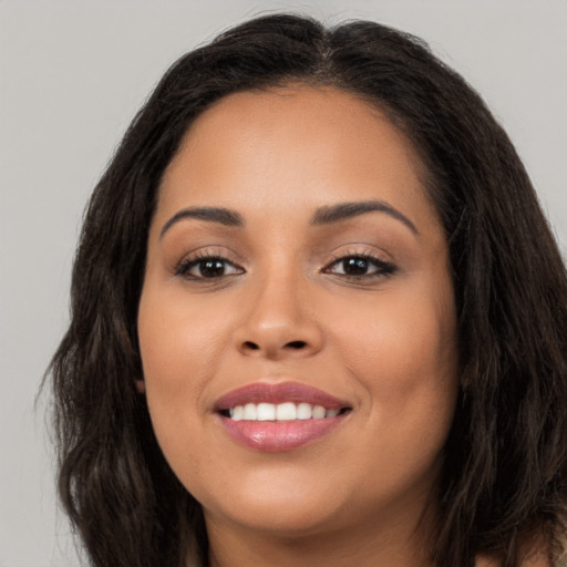 Joyful latino young-adult female with long  brown hair and brown eyes