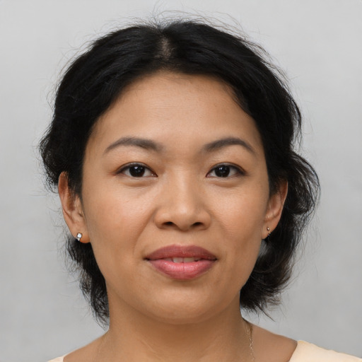 Joyful asian adult female with medium  brown hair and brown eyes