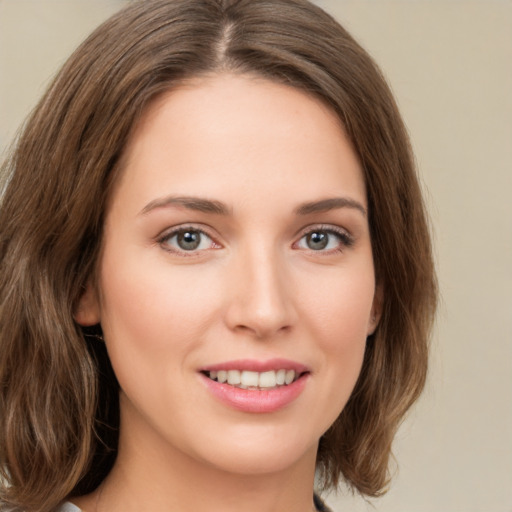 Joyful white young-adult female with medium  brown hair and green eyes