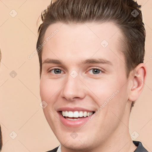 Joyful white young-adult male with short  brown hair and grey eyes