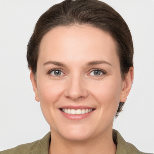 Joyful white young-adult female with short  brown hair and grey eyes