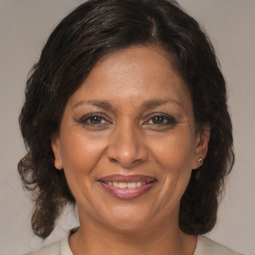 Joyful black adult female with medium  brown hair and brown eyes