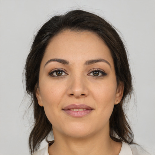 Joyful latino young-adult female with medium  brown hair and brown eyes