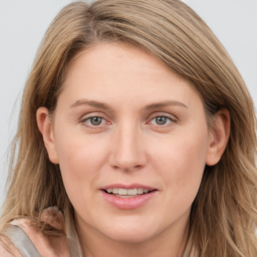 Joyful white young-adult female with long  brown hair and blue eyes