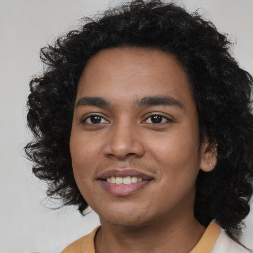 Joyful black young-adult male with long  black hair and brown eyes
