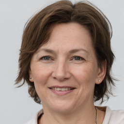 Joyful white adult female with medium  brown hair and grey eyes