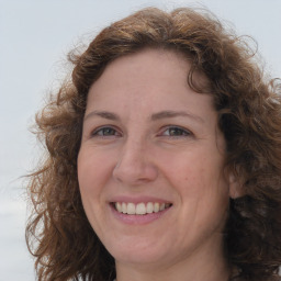 Joyful white adult female with long  brown hair and brown eyes