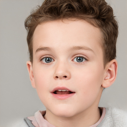 Joyful white child male with short  brown hair and blue eyes