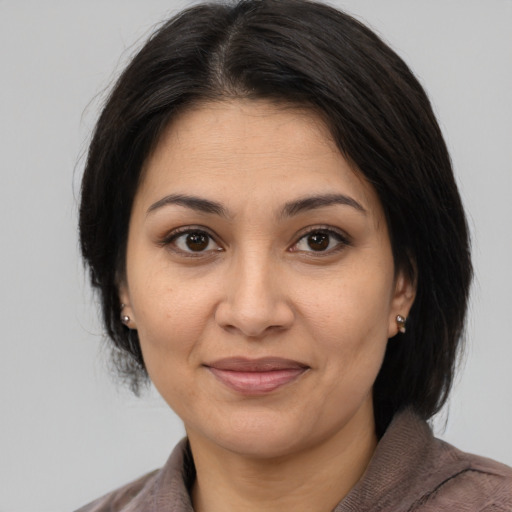 Joyful asian adult female with medium  brown hair and brown eyes