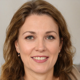 Joyful white young-adult female with long  brown hair and green eyes