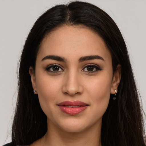 Joyful latino young-adult female with long  brown hair and brown eyes