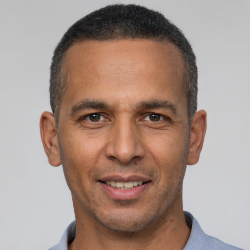 Joyful latino adult male with short  black hair and brown eyes