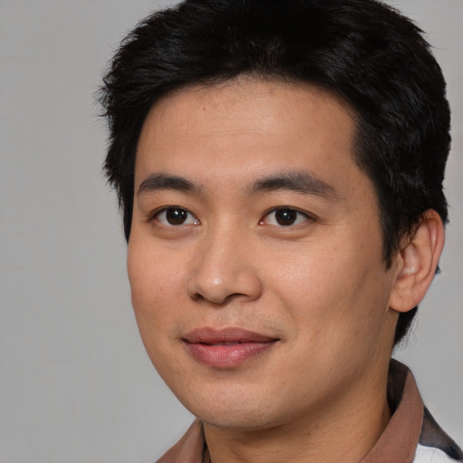 Joyful asian young-adult male with short  brown hair and brown eyes