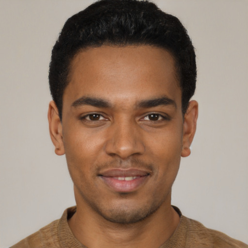Joyful black young-adult male with short  black hair and brown eyes