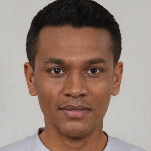 Joyful black young-adult male with short  black hair and brown eyes