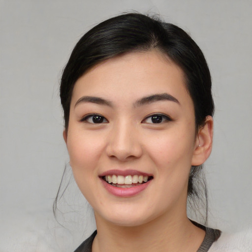 Joyful asian young-adult female with medium  brown hair and brown eyes