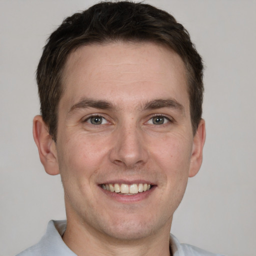 Joyful white adult male with short  brown hair and grey eyes