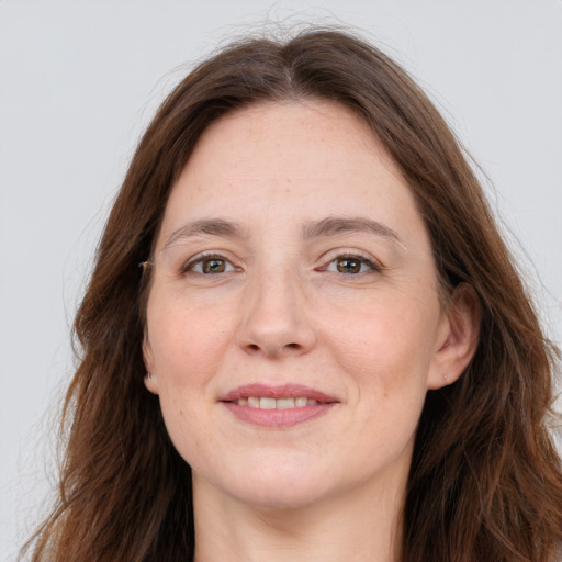 Joyful white adult female with long  brown hair and grey eyes