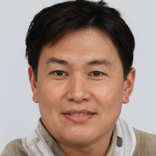 Joyful asian adult male with short  brown hair and brown eyes