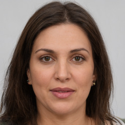 Joyful white adult female with long  brown hair and brown eyes