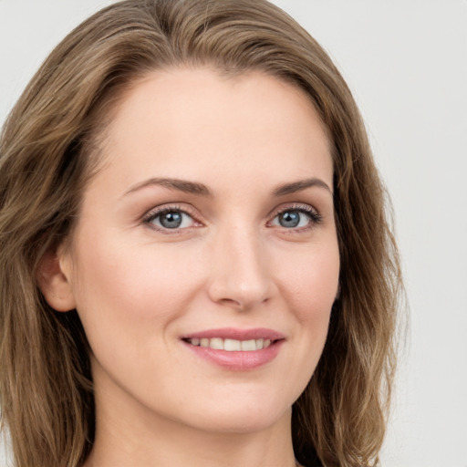 Joyful white young-adult female with long  brown hair and blue eyes