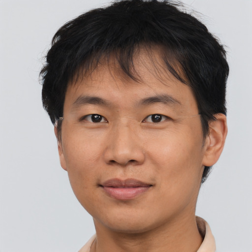 Joyful asian young-adult male with short  brown hair and brown eyes
