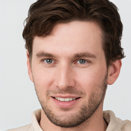 Joyful white young-adult male with short  brown hair and grey eyes