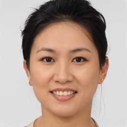 Joyful asian young-adult female with medium  brown hair and brown eyes