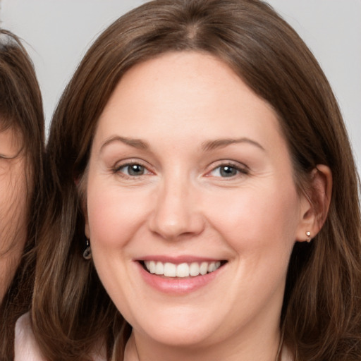 Joyful white adult female with long  brown hair and brown eyes