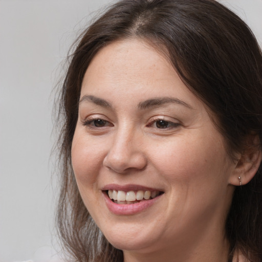Joyful white young-adult female with long  brown hair and brown eyes