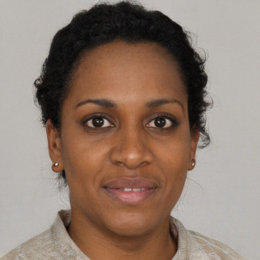 Joyful black adult female with short  brown hair and brown eyes