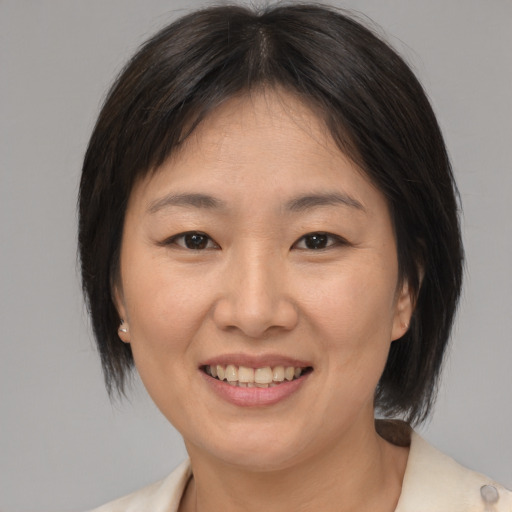 Joyful asian young-adult female with medium  brown hair and brown eyes
