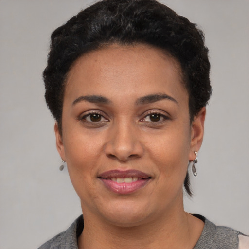 Joyful latino young-adult female with short  black hair and brown eyes