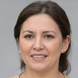 Joyful white adult female with medium  brown hair and grey eyes