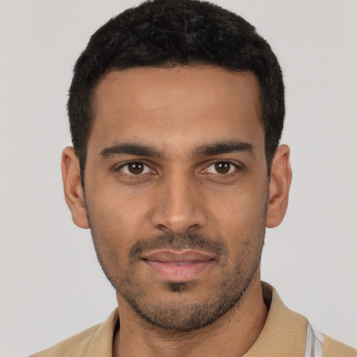 Joyful latino young-adult male with short  black hair and brown eyes