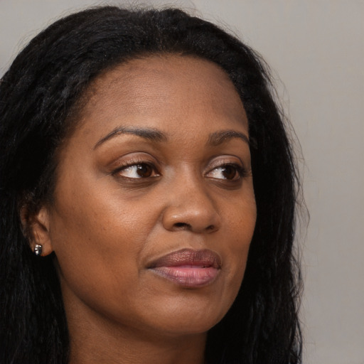 Joyful black adult female with long  brown hair and brown eyes