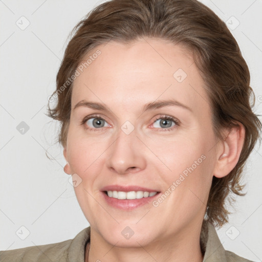 Joyful white adult female with medium  brown hair and grey eyes