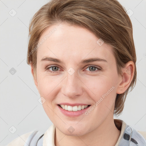 Joyful white young-adult female with medium  brown hair and grey eyes