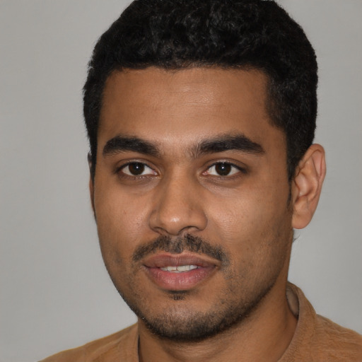 Joyful black young-adult male with short  black hair and brown eyes