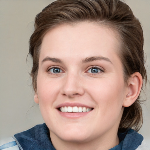 Joyful white young-adult female with medium  brown hair and blue eyes