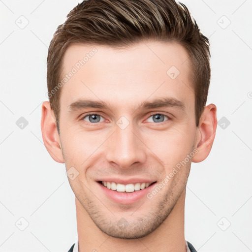 Joyful white young-adult male with short  brown hair and grey eyes