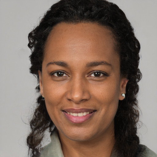 Joyful black adult female with long  black hair and brown eyes