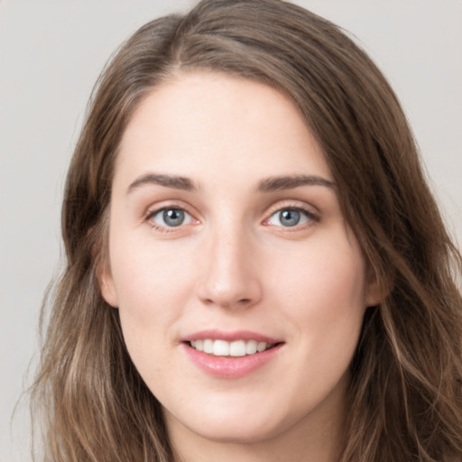 Joyful white young-adult female with long  brown hair and grey eyes