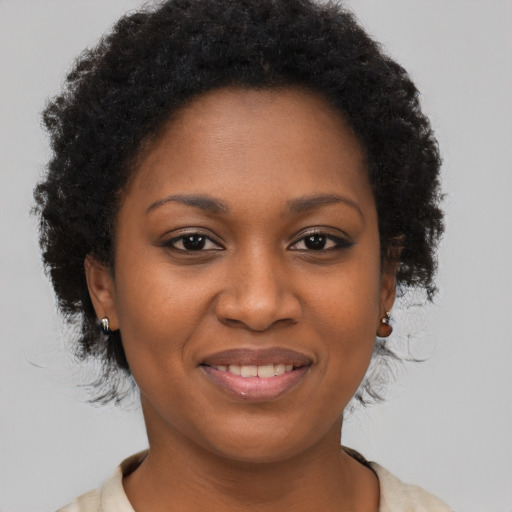 Joyful black young-adult female with short  brown hair and brown eyes
