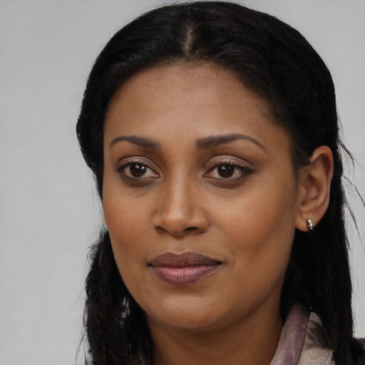 Joyful black young-adult female with long  brown hair and brown eyes