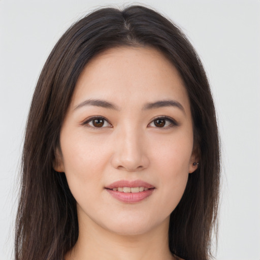 Joyful asian young-adult female with long  brown hair and brown eyes